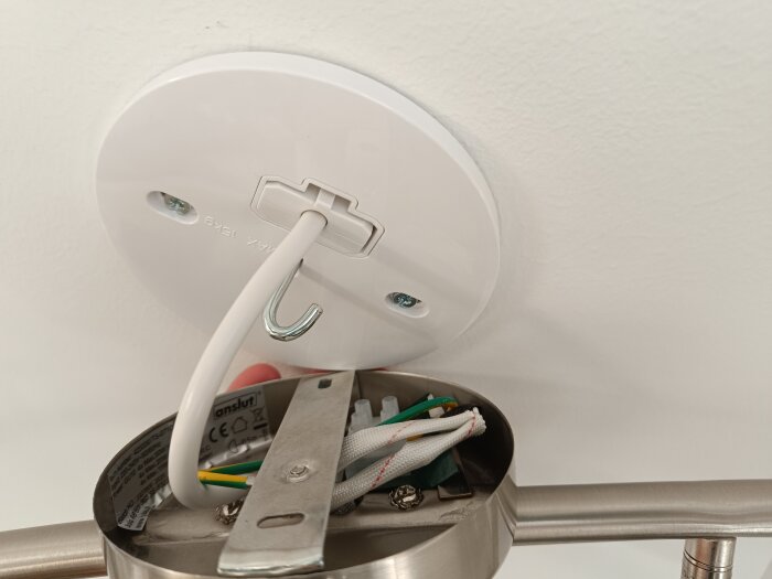 Taklampsinstallation med rund platta, krok, och synliga kablar; problem med att fästa armaturen.