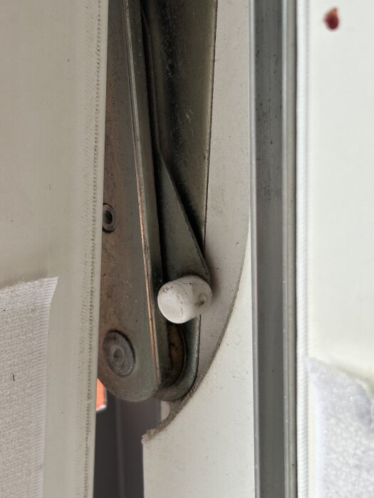 Barnspärr på fönster med vit spak, visar position och låsning i öppet läge.