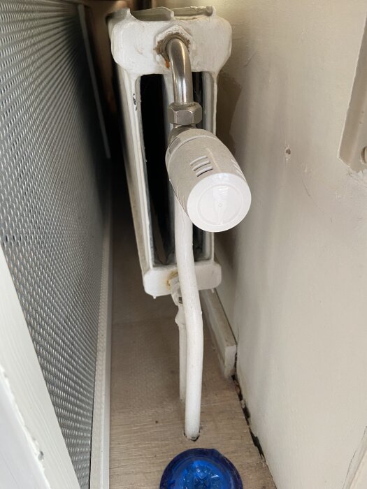 Radiator med termostat kopplad till ett 18 mm rör.