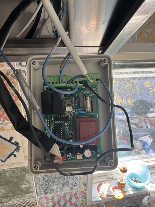 Elslutning med kablar och kretskort nära köksfläkt.