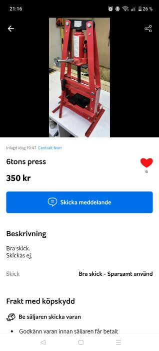 Röd 6-tons hydraulisk press i metall, placerad på en arbetsbänk i ett verkstadsmiljö.