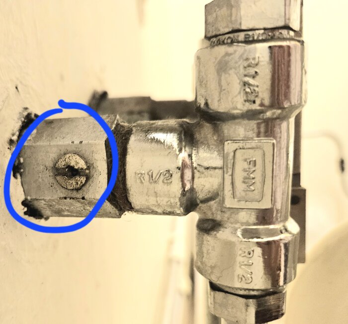 Vattenrörsanslutning med skruvventil, sökandes instruktioner för att stänga av vattnet, markerad med blå cirkel.