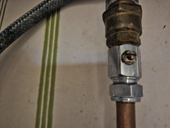 Vattenrör med en ventil och en skruv, visar en koppling där en användare vill stänga av vattnet på ett läckande köksblandare.