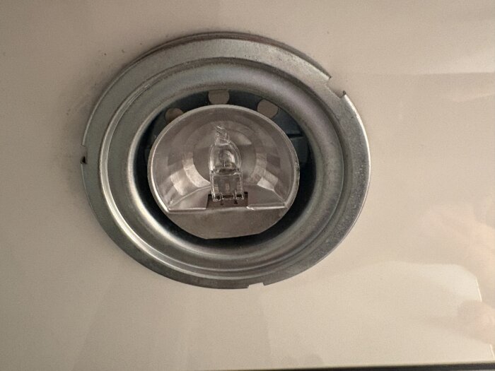 Spot-lampa monterad i badrumsskåp, troligen från Ikea, med glödlampa synlig men svår att avlägsna enligt trådens fråga.