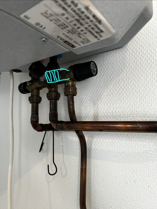 Säkerhetsventil ansluten till kopparrör i stugan. Ventilens utlopp pekar nu mot klockan 8-9, vilket inte passar med det bockade röret.