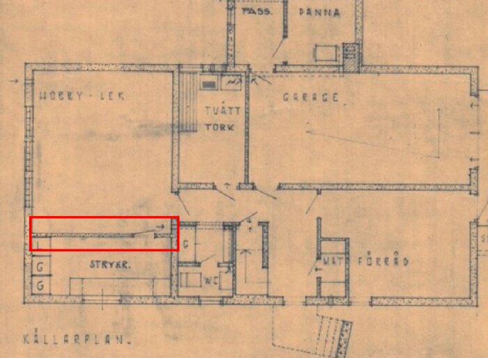 Ritning av källarplan med en rödmarkerad vägg som potentiellt ska tas bort. Visa rum som garage, strykrum och hobby-lek. Huset byggt 1962.