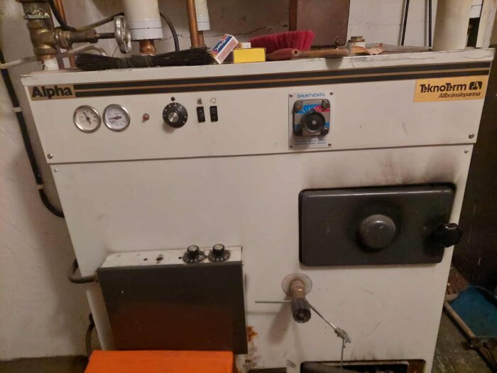 Teknotherm Alpha allbränslepanna med tryckmätare, shuntventil, och två rattar inställda på 60 grader.