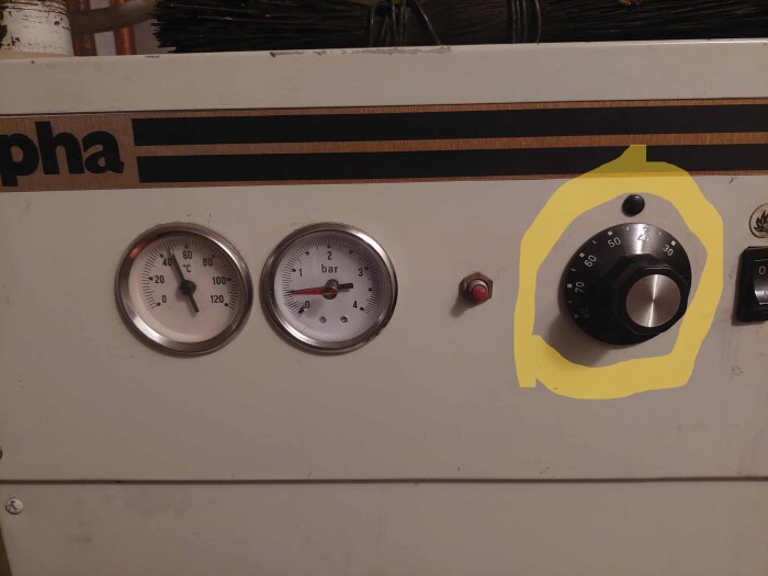 Kontrollpanel på Teknotherm Alpha allbränslepanna med två mätare och en ratt markerad i gult, inställd på 60 grader.