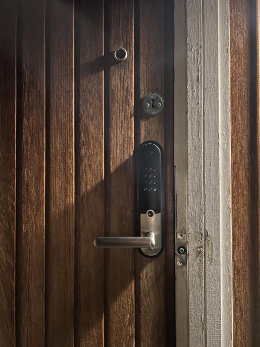 Yale Doorman L3S installerad på en äldre trädörr från 1969 med synligt dörrhandtag och låssystem.