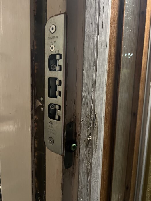 Yale Doorman L3S lås installerat i en äldre dörr med synliga skruvar och träytor.