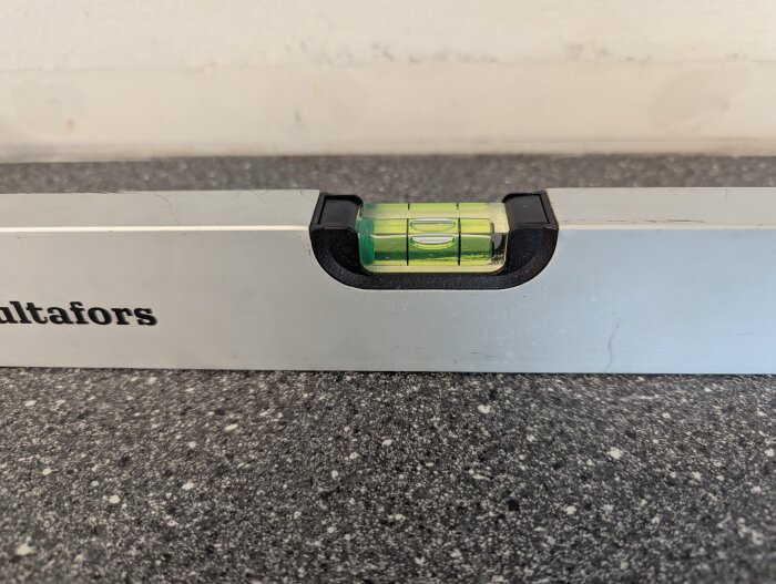 Vattenpass på köksbänk för att justera nivå vid installation av bänkskiva vid diskbänk.