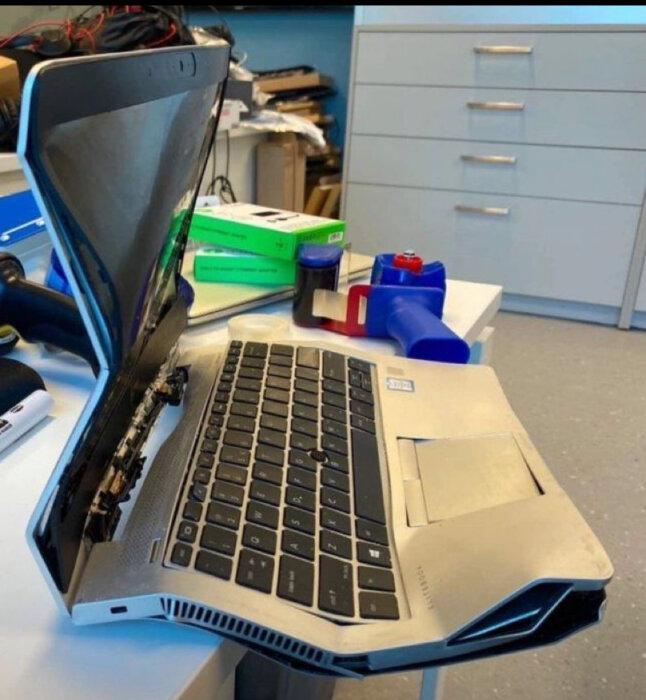 En laptop med en böjd och skadad skärm, möjligen på grund av försummad uppdatering.