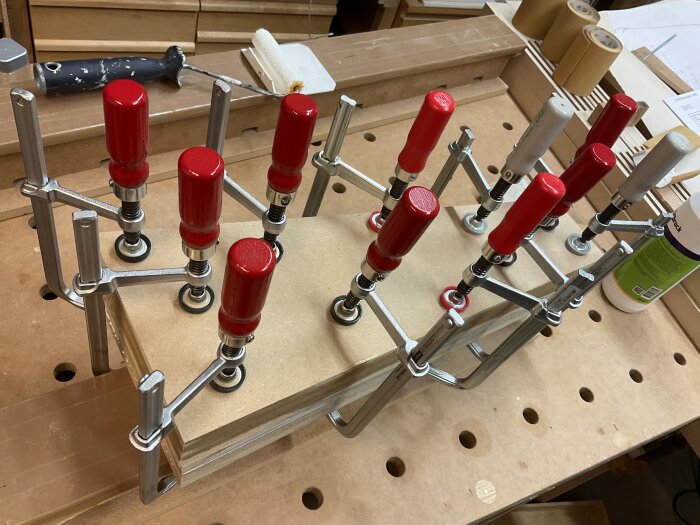 MDF-bitar ihoplimmade med flera tvingar i verkstad.