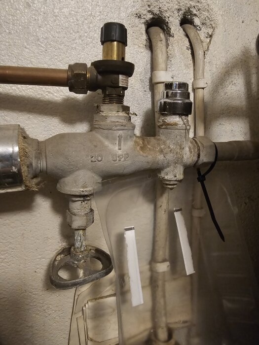 Gammalt ventilrör med säkerhetsventil på ingående vattenledning till varmvattenberedare, kopplat till en gammal kombipanna.