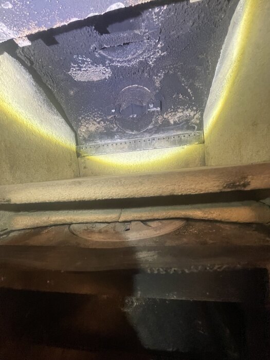 Insidan av en sotig kamin med rökavledarplattor fastsatta, del av en Scan Andersen 4, där det är problematiskt att ta bort plattorna.