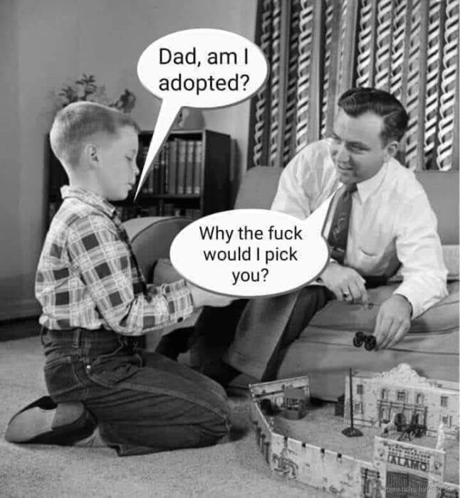 En pojke och en man sitter på golvet och leker med leksaker. Pojken säger att han är adopterad, mannen svarar ifrågasättande.