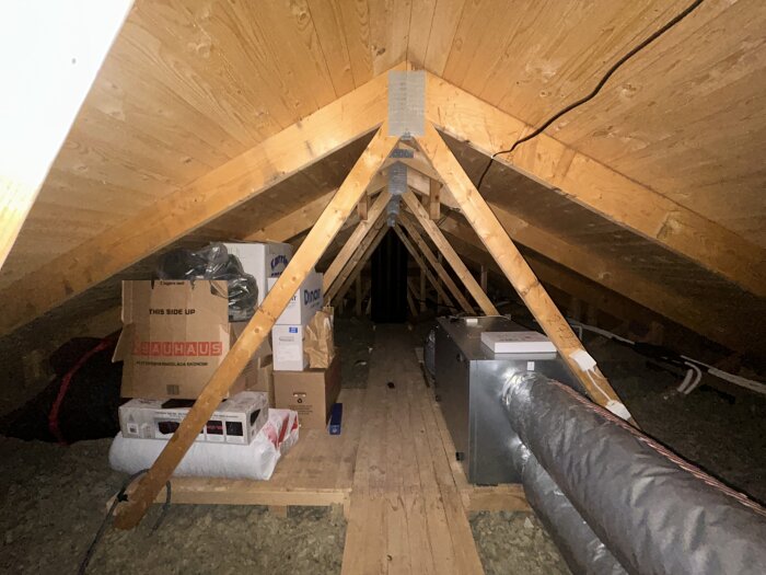 Vind med träbalkar och förvaringslådor, möjligt framtida gästrum eller lekområde för barn. Högsta punkt cirka 190 cm från golv till nock.