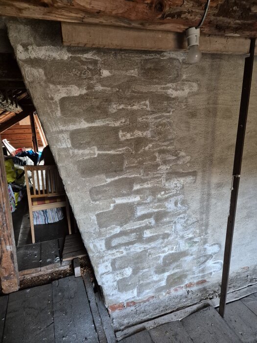 Murstock med vitt mjukt lager liknande bomull, eventuellt mögel eller kalk, synligt i vindsutrymme.