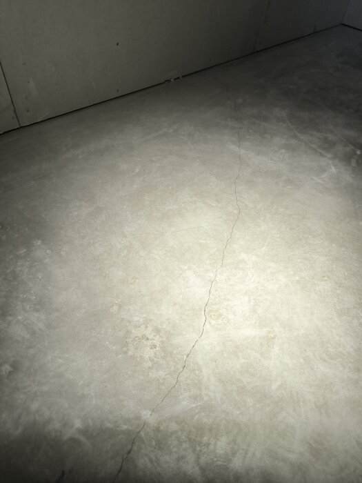 Betonggolv med synlig spricka på ytan, osäkerhet kring när sprickan uppstått, viktigt att avgöra innan golv läggs ovanpå.