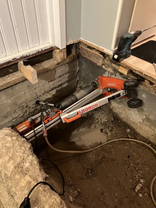 Borrutrustning vid husgrund används för att skapa hål in till ett kryputrymme.