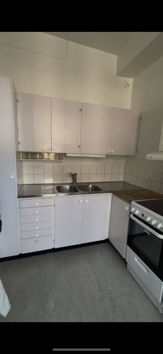 Kök med vit diskbänk, kakel och dubbla diskhoar; underskåp möjligt för bänkdiskmaskin. Lägenhet från 1884.