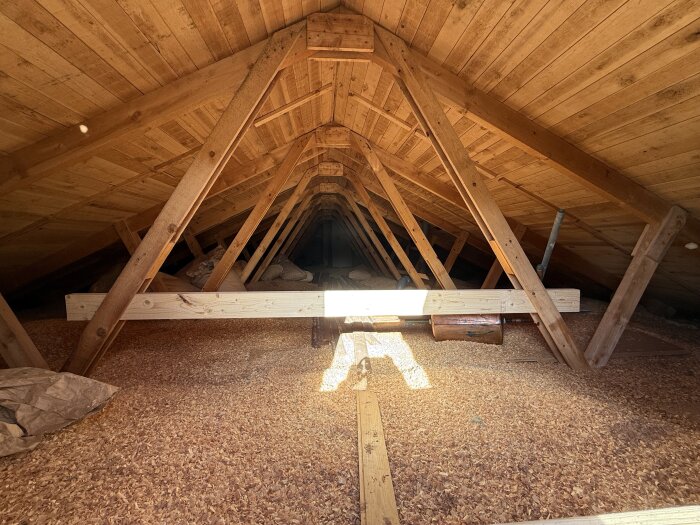 Takstolar och råspont i vinden av ett 1965 Gullringshus, synliga träbalkar och sågspån på golvet, frågan gäller om de är självbärande.