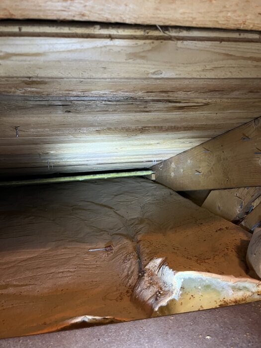 Bild på innertak med tecken på fukt, synliga träbjälkar. Handduk synlig, över två kupor. Taket är 35 år gammalt, övriga delar ser fina ut.