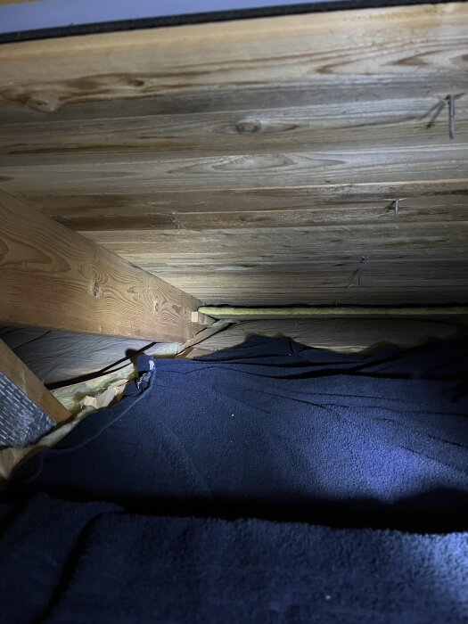 Trätak med åsar ovanför två kupor, en handduk ligger under för att övervaka eventuell fukt. Taket är 35 år gammalt.