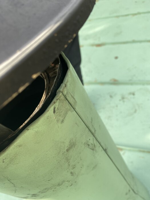 Grön plåt vid skorstensrör med en tydlig glipa, efter renovering av plåtfirma för att åtgärda tidigare brister och byta ut vindskivor.