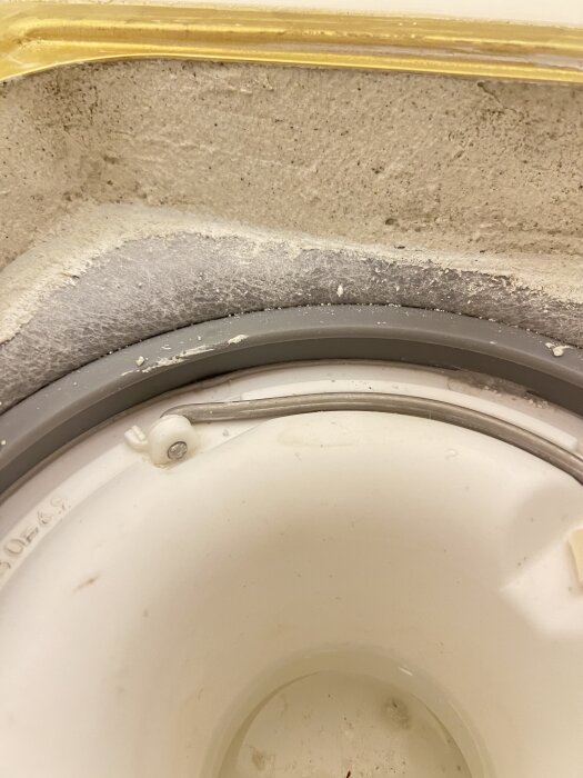 En närbild av en fog och en del av ett vägg hörn, med slitage och damm synligt.