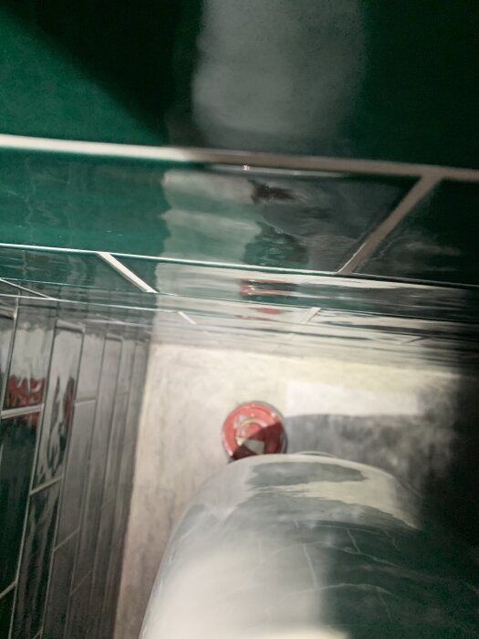 Avloppsanslutning nära vägg bakom toalett, med rörkrök och synligt avlopp, i ett renoverat badrum.