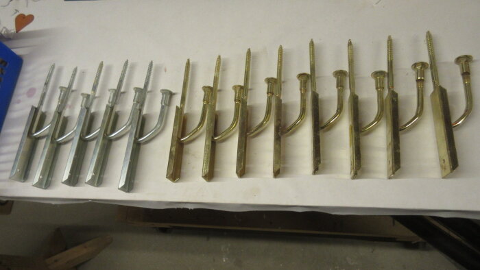 Metallkonsoller i två rader, silver- och guldaktiga, för fönsterbänkar.