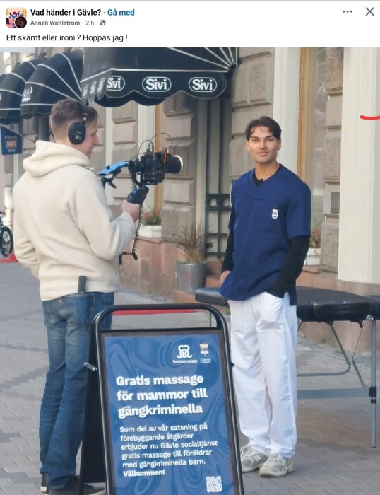 Person i blå uniform filmas utanför butik med skylt som erbjuder gratis massage för mammor till gängkriminella i Gävle, som del av social insats.
