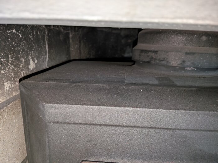 Närbild av en Roslagsspis med fokus på den övre delen och skorstenen, i en diskussion om verkningsgrad och identifiering av spismodell.