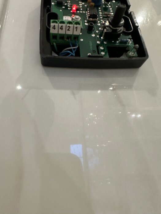 Öppen termostat med kretskort och lysdiod, markerad med siffrorna 4421.