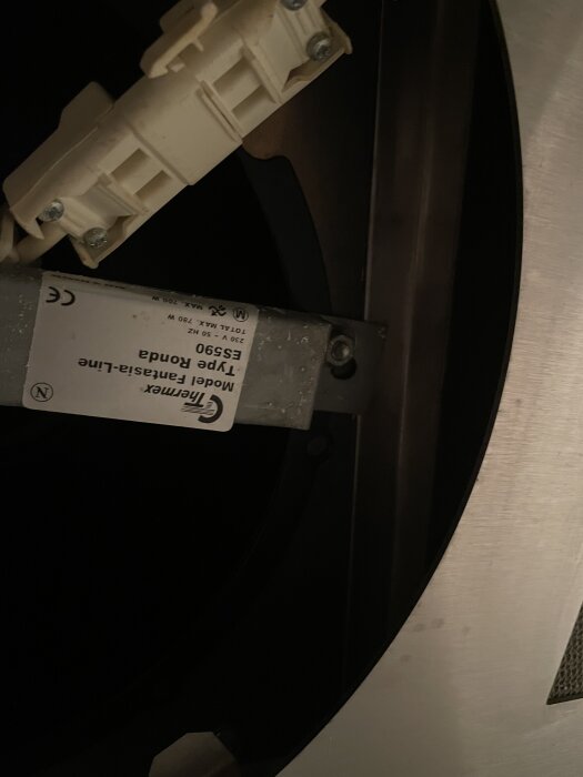 Mekanisk fläkt från 2004 med märkningen Thermex TYP ES950 synlig på en etikett, omgiven av elektriska anslutningar och metallkomponenter.