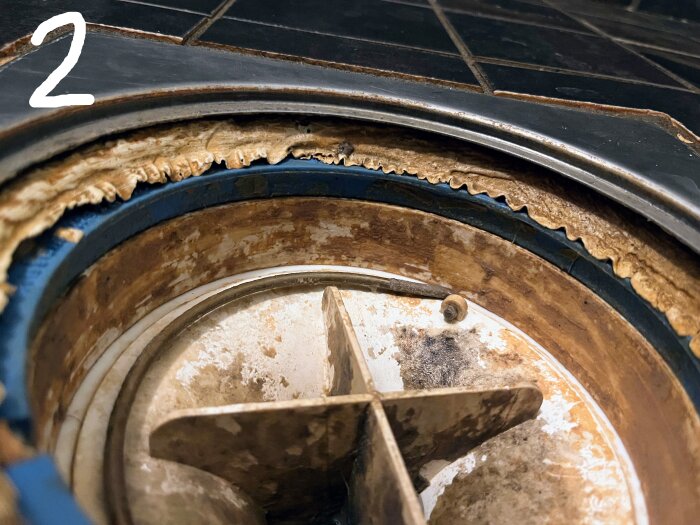 Duschavlopp med otät klämring och synliga beläggningar som behöver åtgärdas för att säkerställa tätskiktet.