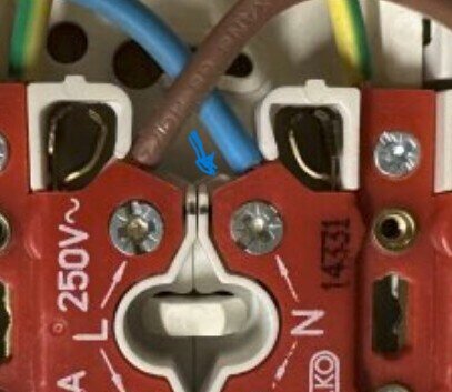 Två elektriska kablar kopplade till en kontakt, markerade hål för att rymma ytterligare kabel vid varje skruv.