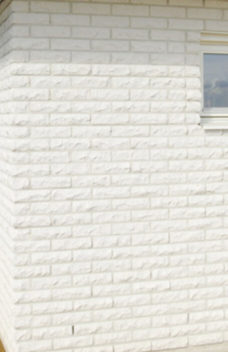 Vit tegelfasad med homogena fogar, eventuell inspiration från Yxhult Tegel för byggprojekt eller restaurering av husfasad.