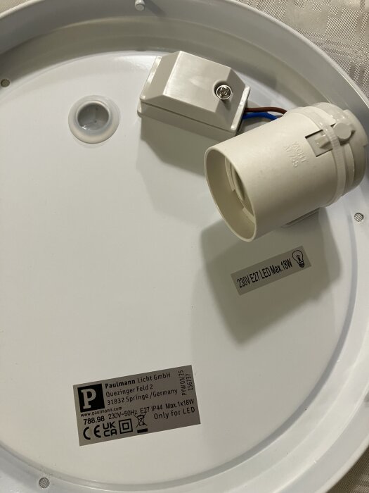 Baksidan av en badrumslampa med E27-sockel och anslutningsbox, märkt för LED 230V Max 18W, från Paulmann.