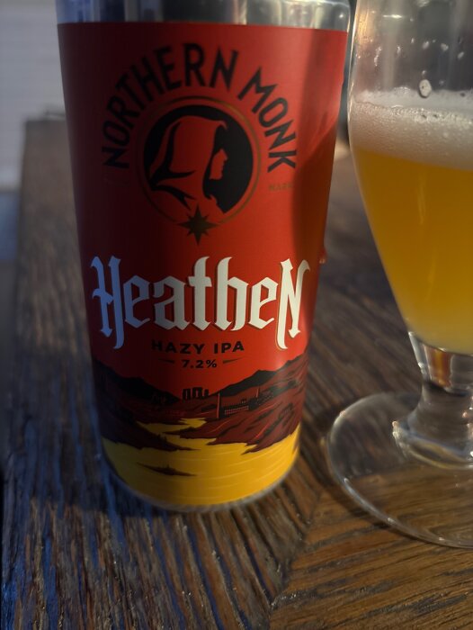 Ölburk av märket Northern Monk Heathen Hazy IPA 7.2% står bredvid ett glas med ljus öl.