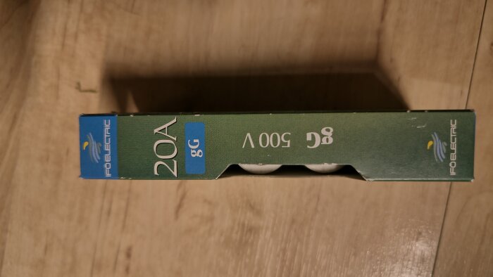 Förpackning med 20A säkringar från Ifö Electric, blå och grön design, delvis uppackade, placerad på träyta.