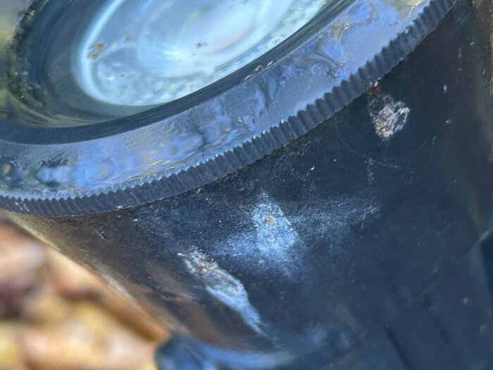 Räfflad ring på en svart yta med tecken på oxidation.