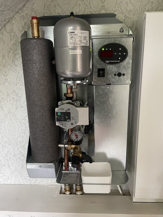 Elektrisk värmepanna Värmebaronen MP6 G2 med expantionstank, tryckmätare och kontrollpanel installerad i ett sommarhus.