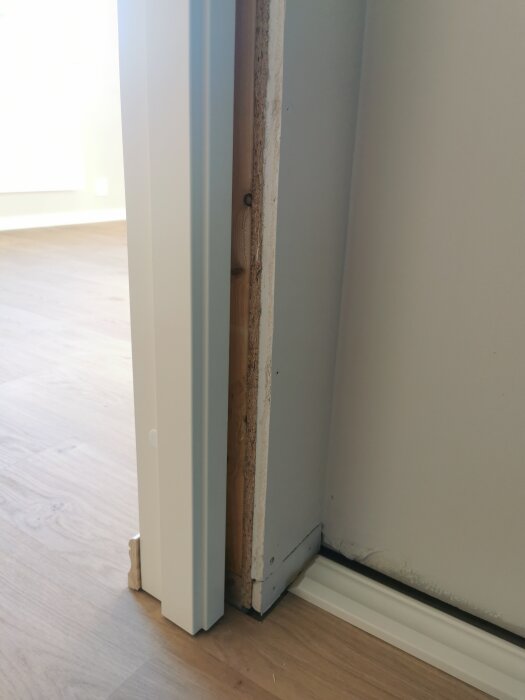 Dörrkarmsfoder med ojämn glipa mot väggen i en pågående renovering av utbyggnad.