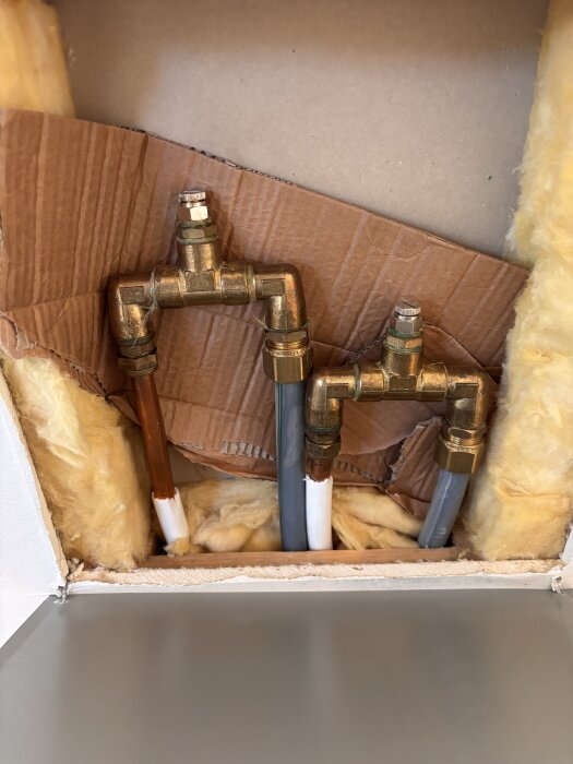 Rörkopplingar och isolering i en vägg vid övervåningens badrum.