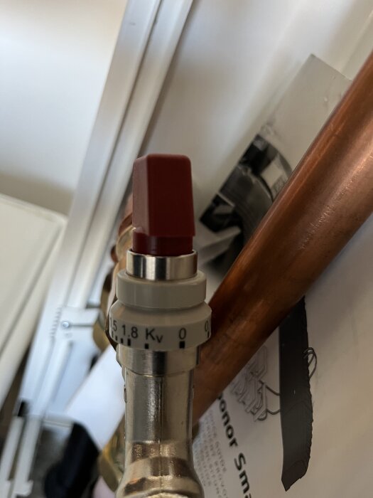 Flödesventil för golvvärme med röd justeringsknapp och gradskala.