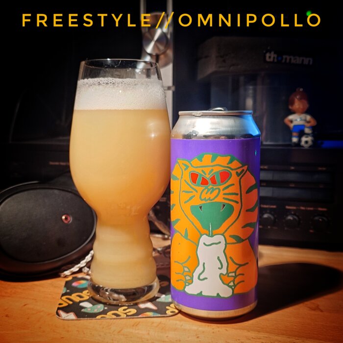 Ett ölglas med skummande öl bredvid en färgglad ölburk med ett tigerliknande motiv mot en mörk bakgrund.