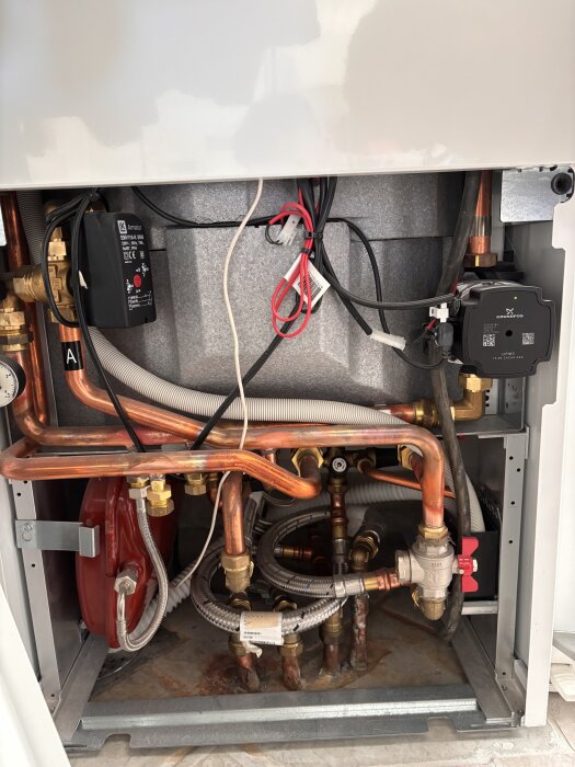 Invecklad rörledning och ventiler i ett bergvärmesystem, med cirkulära pumpdetaljer och märkta rör för badrummet och ballofixventil.