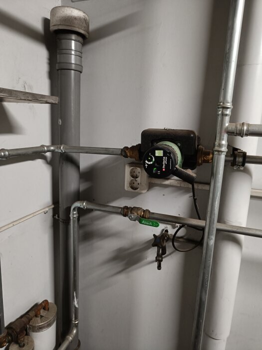 Cirkulationspump Perfecta aPump 25-4U/180 installerad bland rör och ventiler i ett pannrum, del av värmeanläggning i en villa.